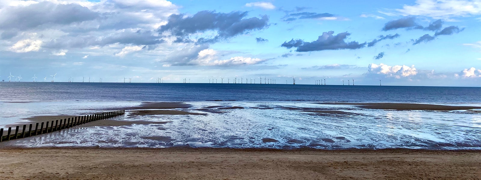 Beach with wind farm in distance