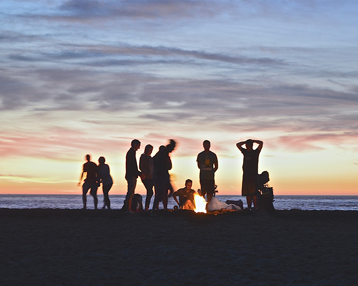 People on a beach around a fire