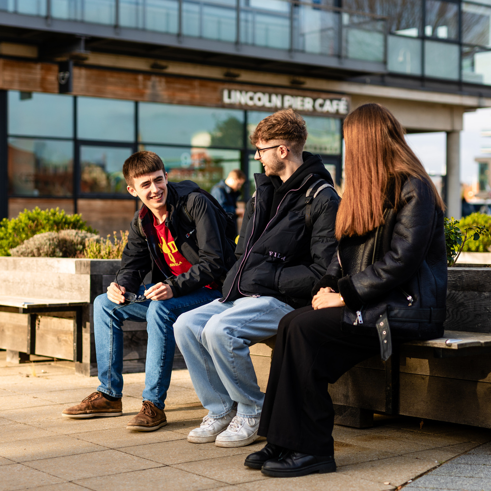 A group of students talking outside of a building