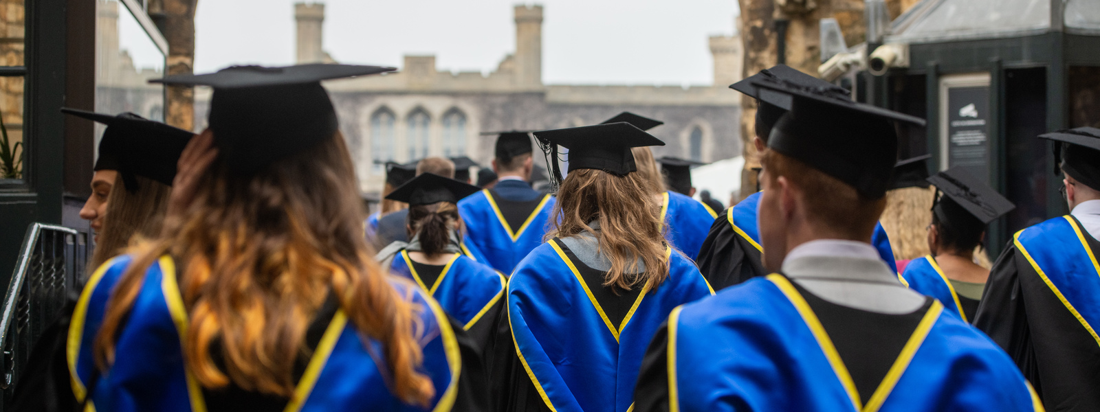 Students walking in graduation caps and gowns