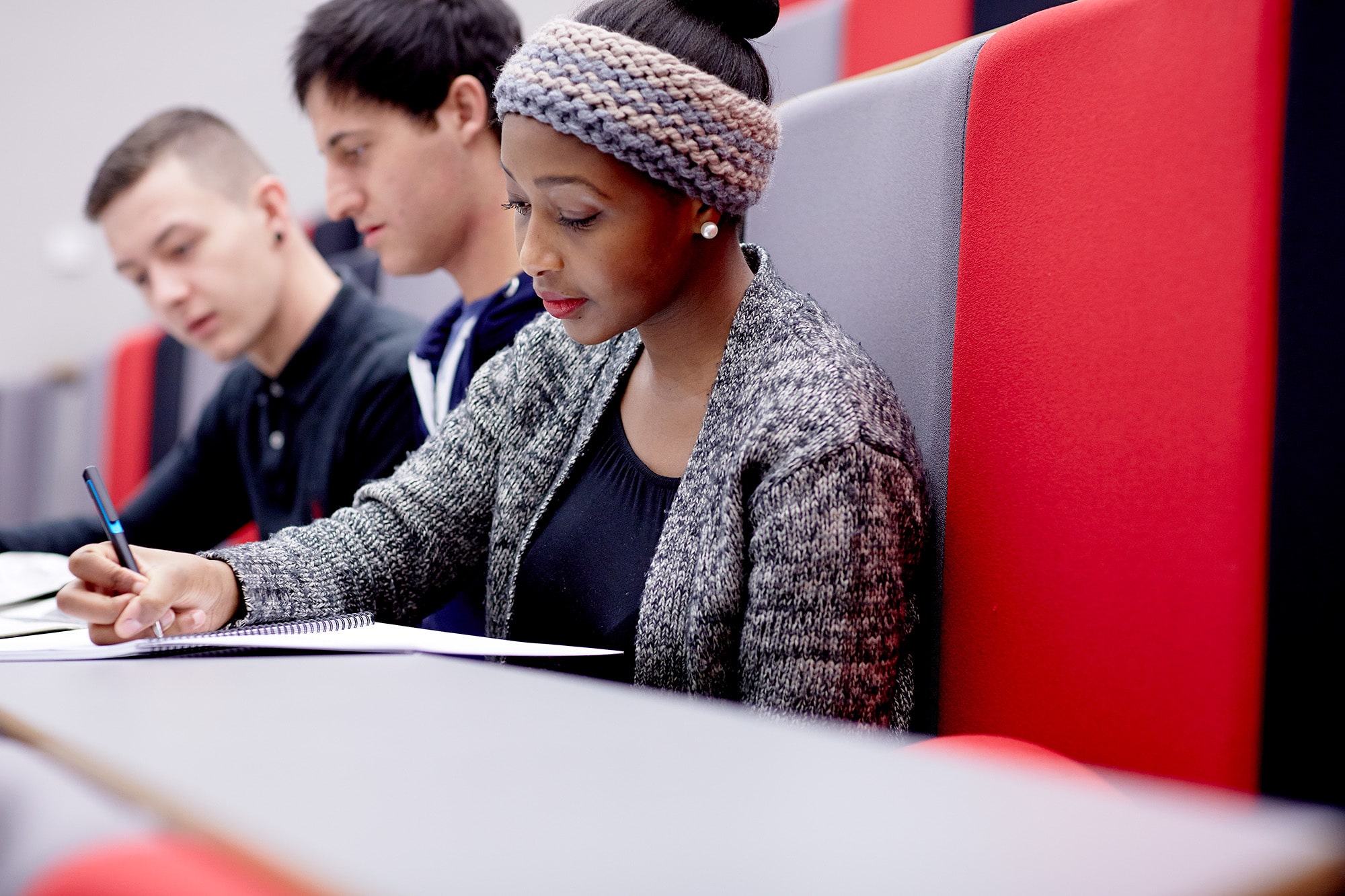 Student writing notes in a lecture.