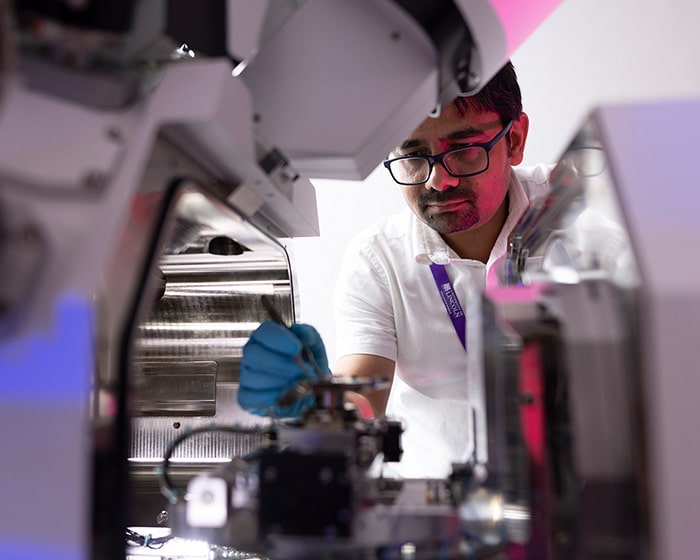 Man working in a lab environment wearing a University of Lincoln lanyard