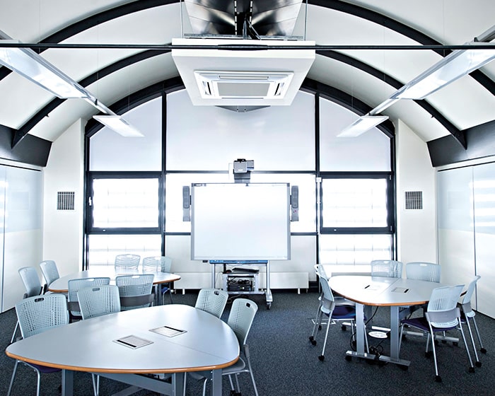 A shot fo an empty meeting room with a smart board and tables