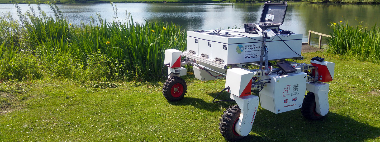 Thorvald robot on a grass bank near water