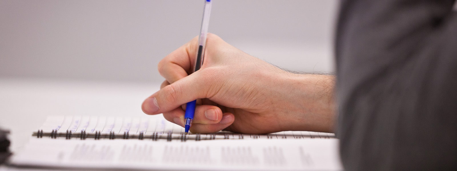 Close-up of student writing in notebook