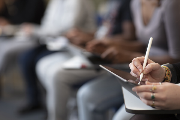 Students sat writing on tablets