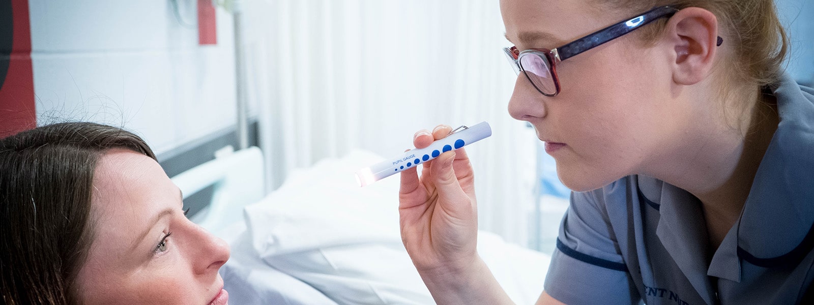 Student nurse performing eye check