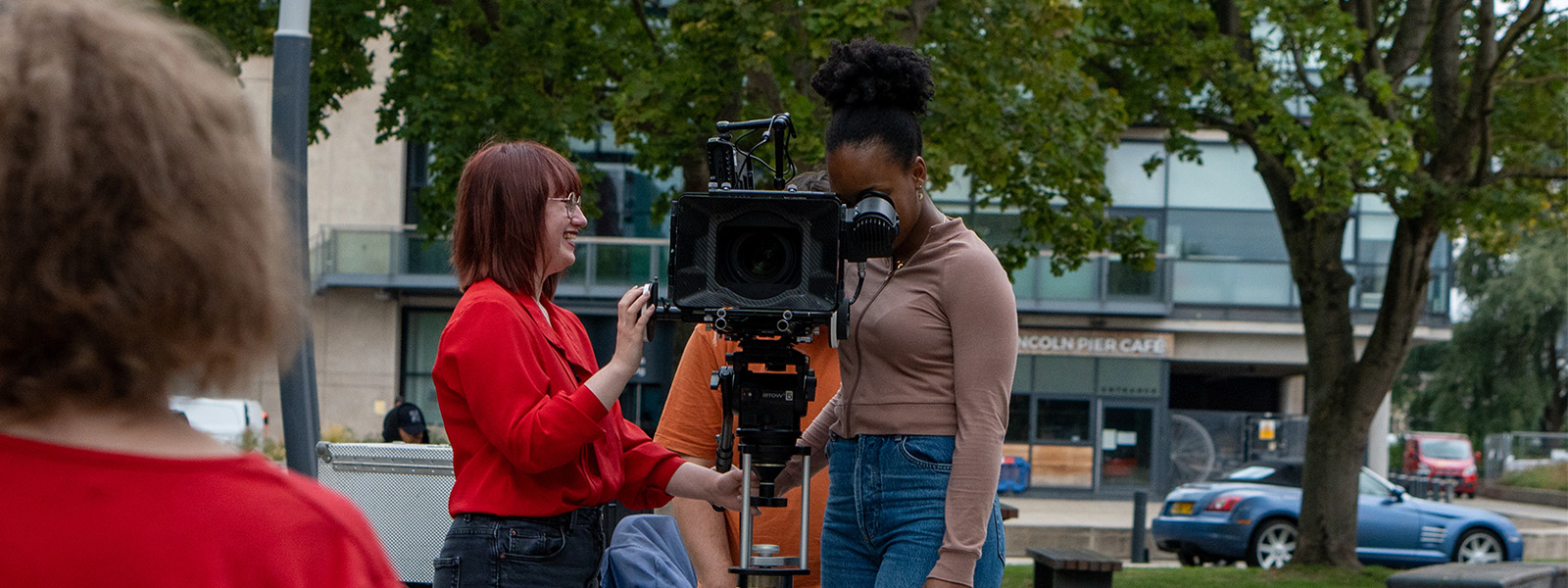 Students outside using a professional film camera