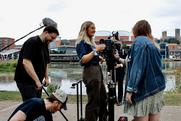 Students using a film camera outside