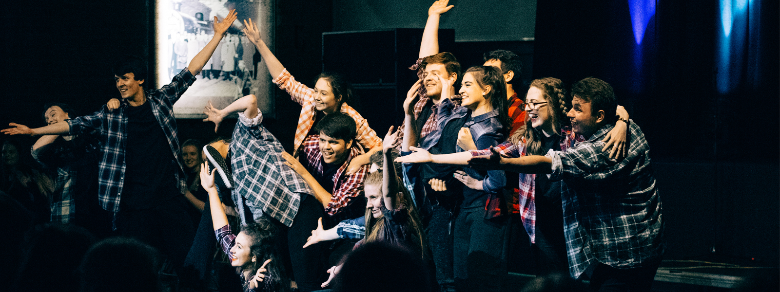 Group of students posing on stage during a performance 