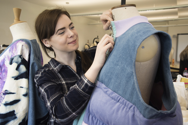 A fashion student working on a clothes model