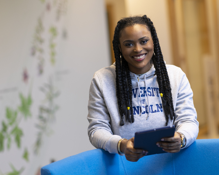 A student holding a tablet device