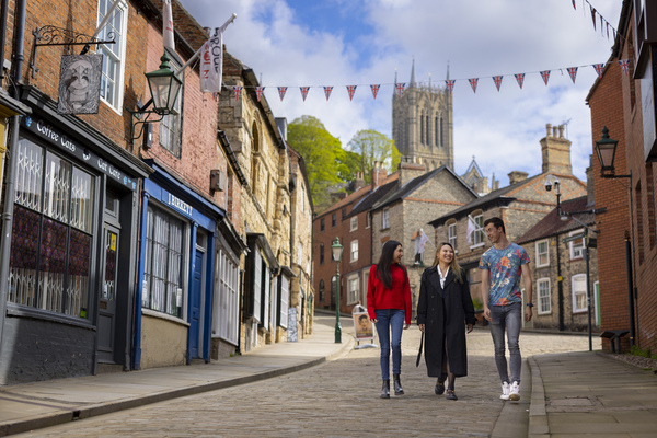 three students walking down steephill