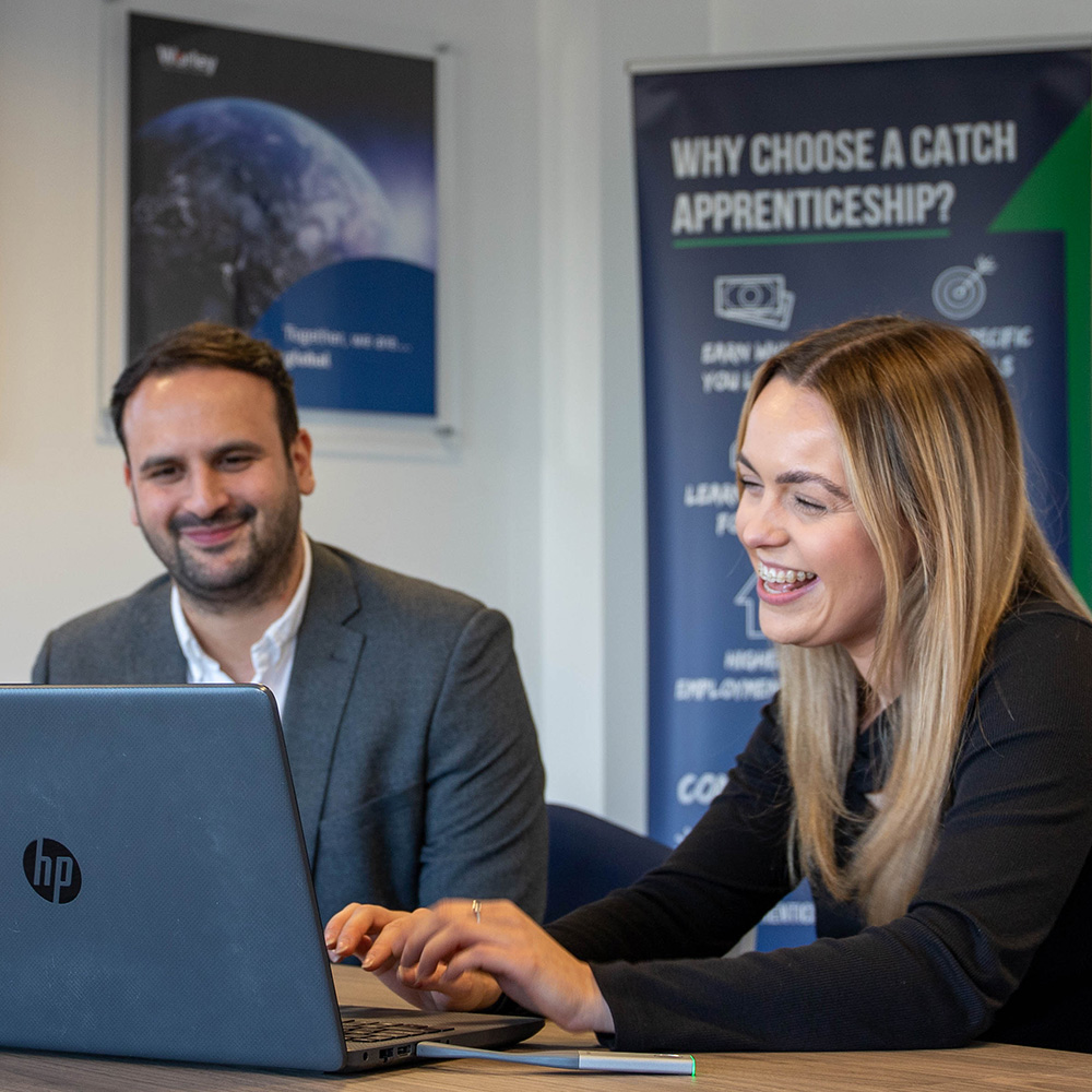 Employer and apprentice looking at laptop