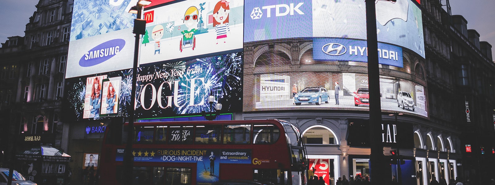 A large screen on the side of a building displaying advertisements