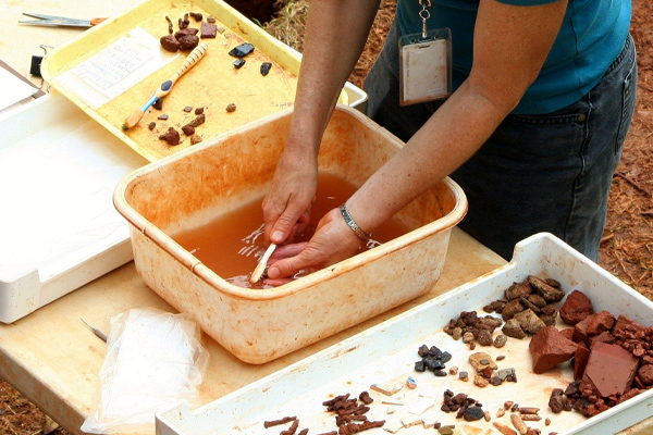 Somebody cleaning artefacts taken from a dig