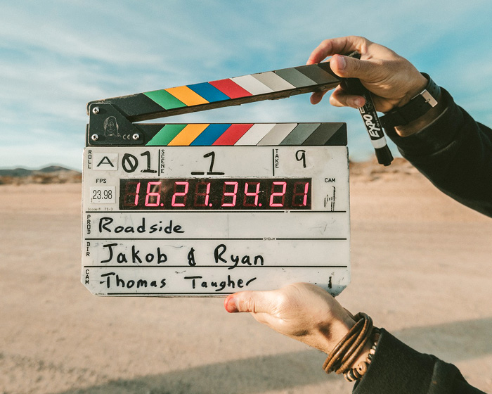 A pair of hands holding a film clapperboard