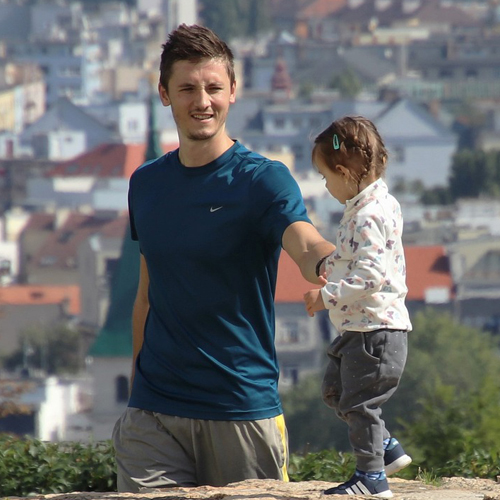 A young father walking with his daughter