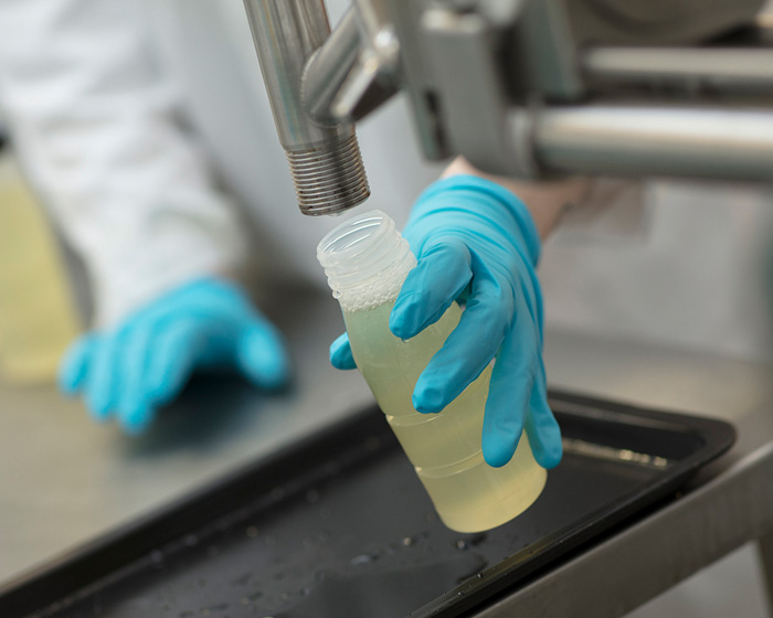 A bottle being filled from a machine in a lab