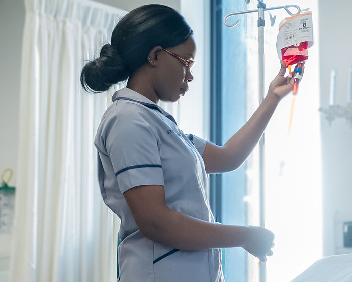 A student nurse looking at an IV Drip